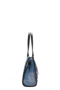 Side view of the Bosque de Amor denim tote bag featuring black straps and a stylish design.